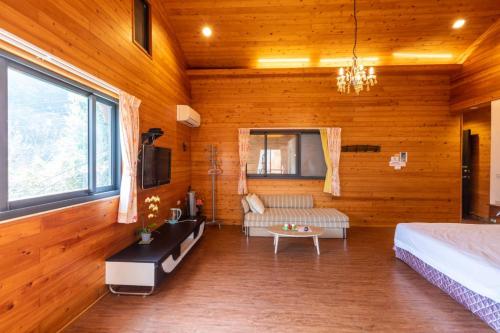 a bedroom with wooden walls and a bed and a couch at Walk Cloud Bed and Breakfast in Meishan