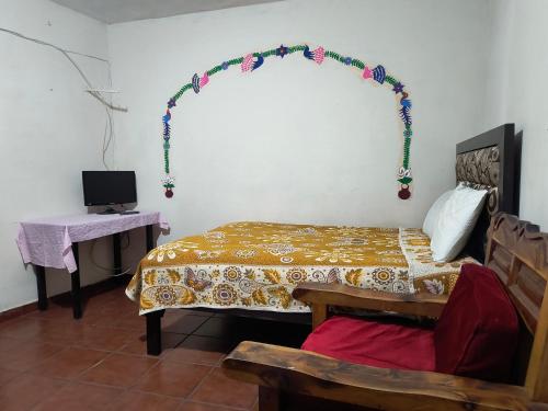 a bedroom with a bed and a table with a desk at Casa del Patrón Posada in Taxco de Alarcón