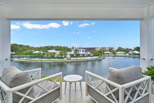 a balcony with chairs and a view of the water at Deja View Trinity Beach in Trinity Beach