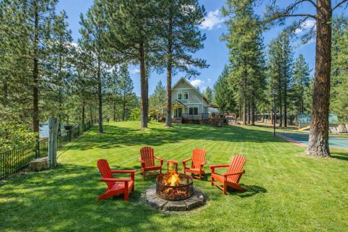 a group of red chairs around a fire pit in a yard at Recharge by The River by NW Comfy Cabins in Leavenworth