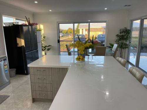 a kitchen with a large white counter with flowers on it at Ensuite room in Mount Duneed in Mount Duneed