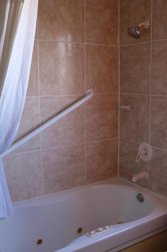 a bathroom with a bath tub with a shower curtain at Budget Inn On Historic Route 66, Barstow in Barstow