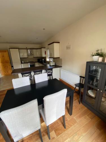 a kitchen and dining room with a table and chairs at Rockside Villa Cashel Sleeps 6, Jacuzzi Bath, Walk to Rock of Cashel in Cashel