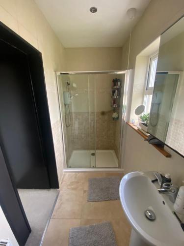 a bathroom with a shower and a sink at Rockside Villa Cashel Sleeps 6, Jacuzzi Bath, Walk to Rock of Cashel in Cashel