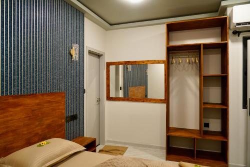a bedroom with a bed and a mirror at Havaa Inn Dhangethi in Dhangethi