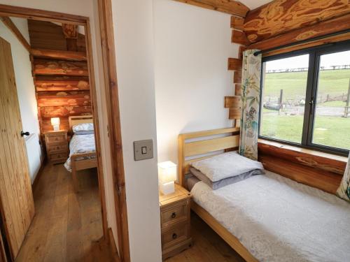 a bedroom with two beds in a log cabin at Cedar Cabin at Salford Court Farm Fishing Cabins in Worcester