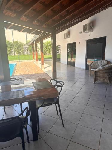 a living room with a table and chairs and a pool at Pousada luz do Sol in Cacoal