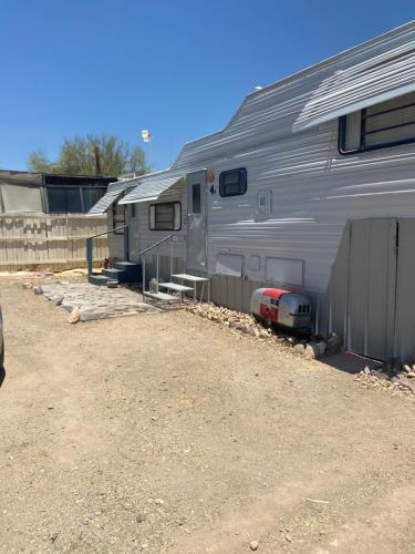 a silver trailer is parked next to a fence at Cozy Private 5th Wheel AC Pet Friendly in Tucson