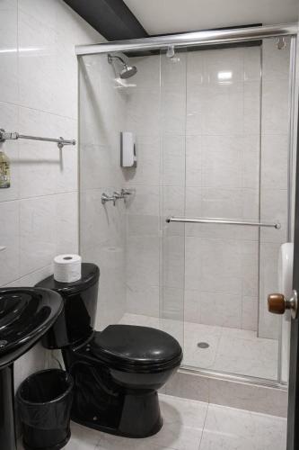 ein Badezimmer mit Toilette und Glasdusche in der Unterkunft Hotel Oicatá in Duitama