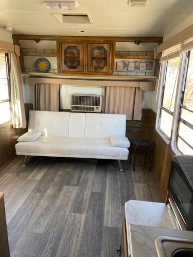a living room with a white couch in an rv at Cozy Private 5th Wheel AC Pet Friendly in Tucson