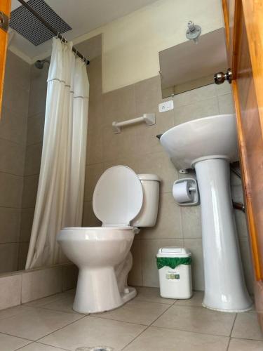 a bathroom with a toilet and a sink at Hostal Casa Cotopaxi in Latacunga