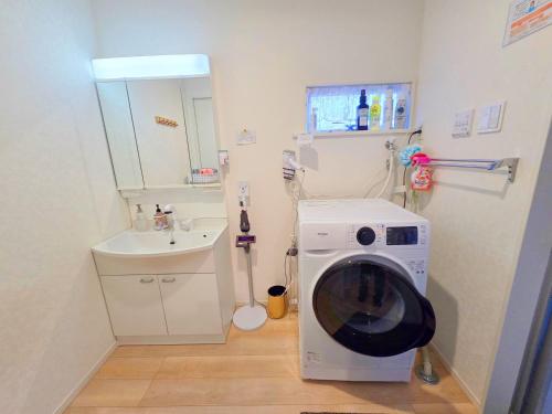 a washing machine in a bathroom with a sink at 家族連れ等に最適な新築つくばガーデンハウス一棟貸切 in Tsukuba