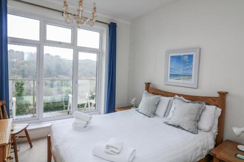 a bedroom with a bed and a large window at 1 Hazeldene in Salcombe