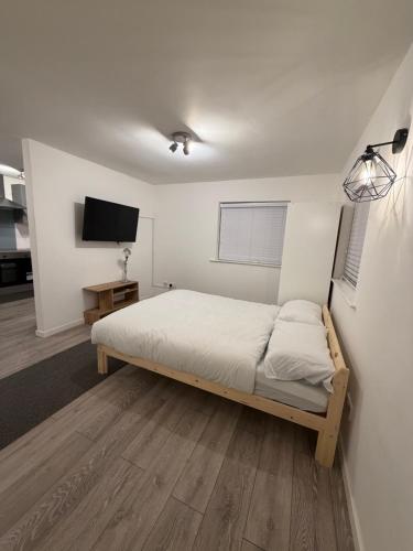 a bedroom with a bed and a flat screen tv at Valley house in Nottingham
