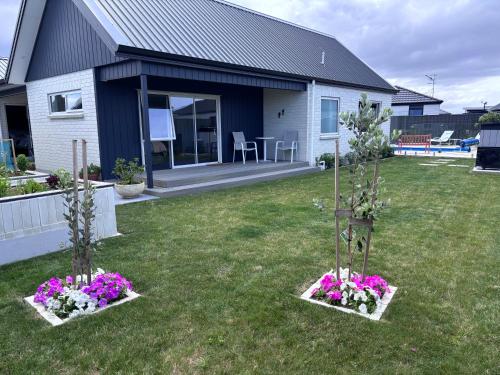 two small trees in a yard with flowers at Bestern on Mohaka in Napier