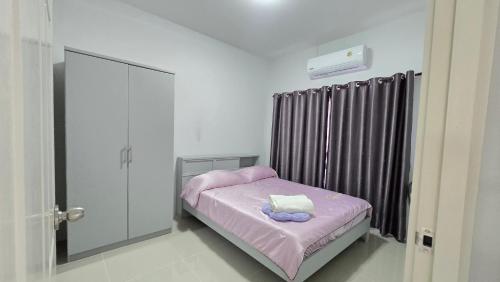 a small bedroom with a small bed with a purple blanket at Joyful House Naiyang beach in Thalang