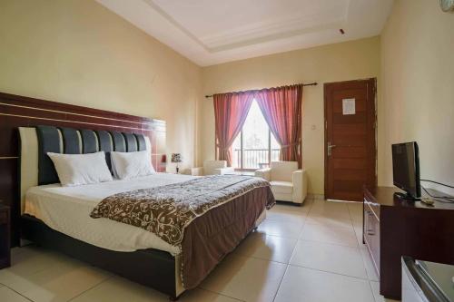 a bedroom with a large bed and a television at Wisma Belerang Kalianda Lampung RedPartner in Kalianda