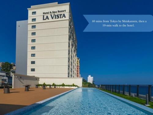 a building with a swimming pool in front of a building at La Vista Atami Terrace in Atami