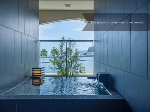 a swimming pool in a building with a view of the water at La Vista Atami Terrace in Atami