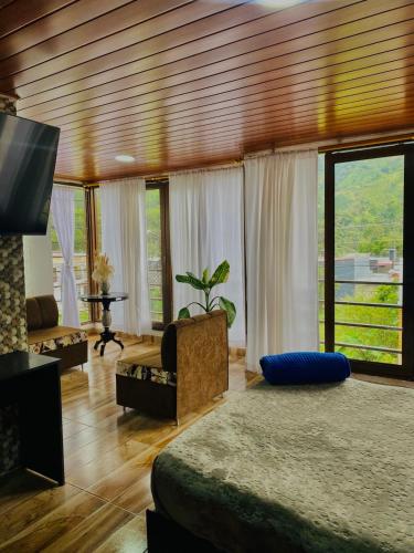 a living room with a bed and a television at Loft Del Ruiz - Apartamentos in Líbano