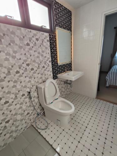 a bathroom with a toilet and a sink at Dolce Home suratthani in Suratthani