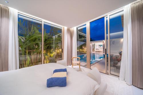 a bedroom with a bed and a large window at Asherah Villa By Asherah Team in Ban Phru Champa