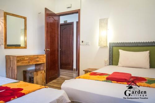 a bedroom with two beds and a mirror at Garden Village Guesthouse & Pool Bar in Siem Reap