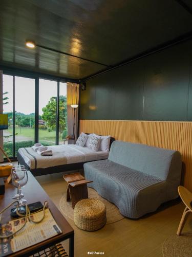 a living room with a bed and a couch at Naramountainkhaoyai in Ban Tha Chang