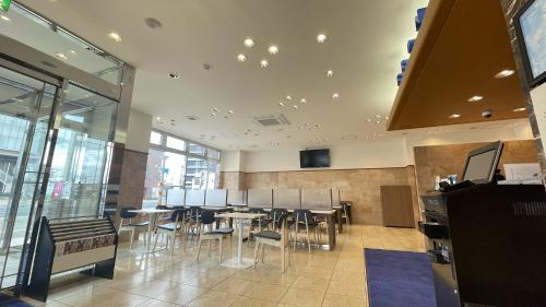 a dining room with tables and chairs in a building at Toyoko Inn Izumo-shi Ekimae in Izumo