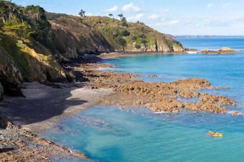 a beach with blue water and a rocky shore at ZEcamping 3 étoiles animaux acceptés à proximité des plus beaux sites in Pordic