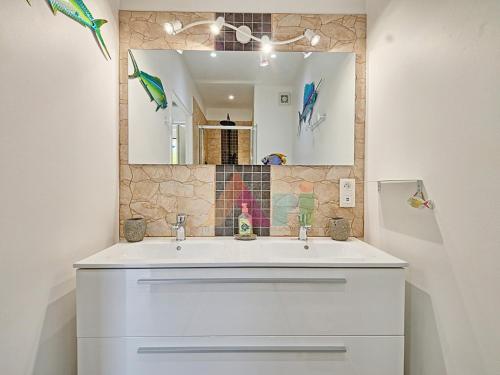 a bathroom with a white sink and a mirror at Studio à Anse Marcel - FR-1-734-86 in Marigot