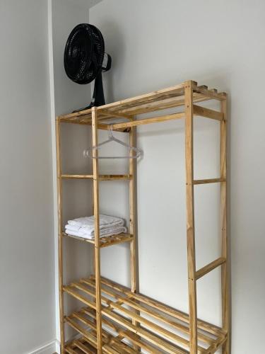 a wooden shelf against a wall with a fan at Apto moderno e aconchegante in Ponta Grossa
