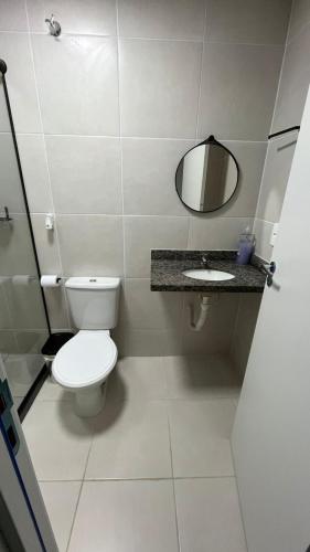 a bathroom with a white toilet and a mirror at Apto moderno e aconchegante in Ponta Grossa