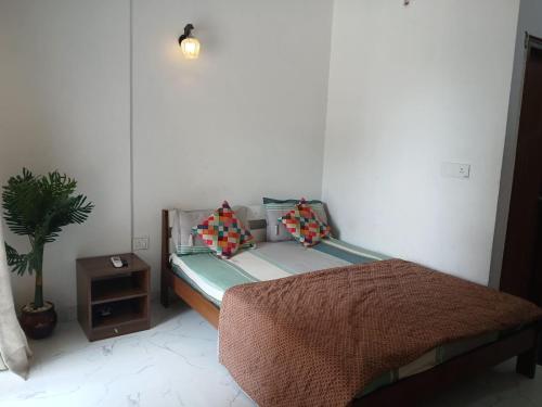 a bedroom with a bed and a potted plant at ATS Grand Casa 02 in Greater Noida