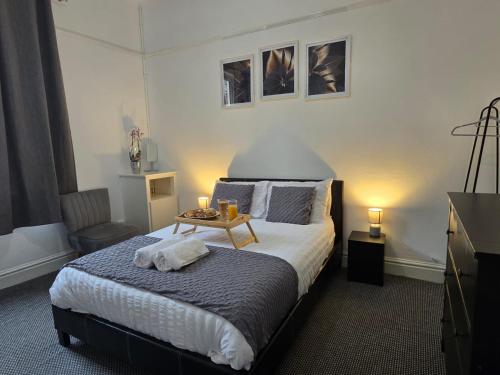 a bedroom with a bed and a table with two candles at Cheerful Home near Preston train station & Uclan in Preston