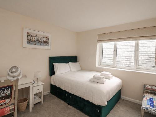 a bedroom with a bed with towels on it at Full Deck in Dartmouth