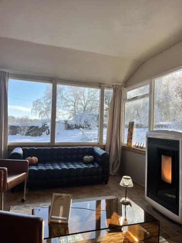 a living room with a couch and a fireplace at La Estancia in Montsauche