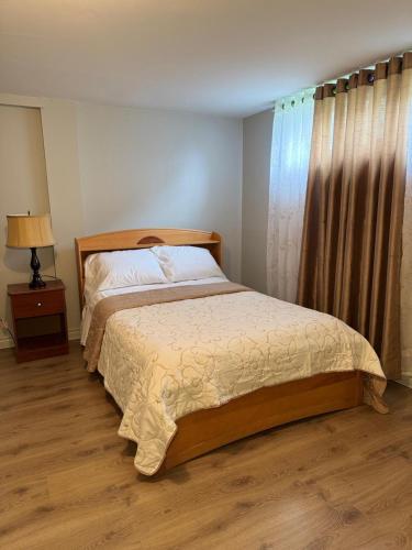 a bedroom with a bed and a lamp and a window at Residence Havre d'abraham in Laval