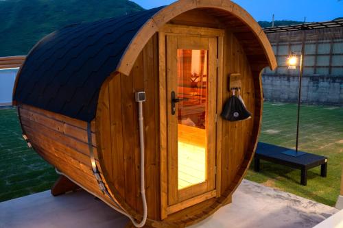 a circular wooden hobbit house with a door in a yard at sante 4073 STAY & SAUNA HAKATA ISLAND #1 AROZU in Imabari