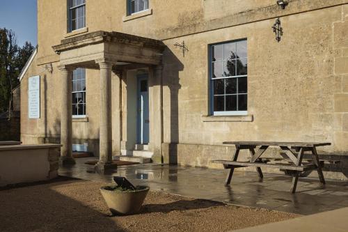 a wooden picnic table in front of a building at King William in Bath