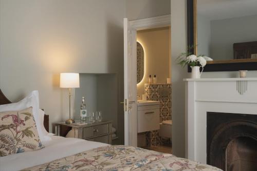 a bedroom with a bed and a fireplace and a bathroom at King William in Bath