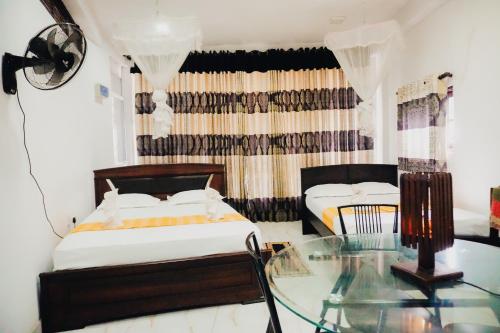 a bedroom with two beds and a glass table at SECRET MIRAGE Ella in Ella