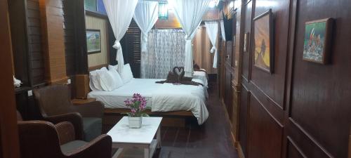 a hotel room with a bed and two chairs at Mangrove House Lanta Old Town in Ko Lanta