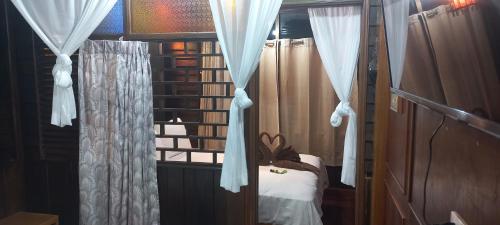 a room with a window with curtains and a bed at Mangrove House Lanta Old Town in Ko Lanta