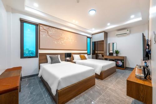 a hotel room with two beds and a television at Hoa Lu Majestic Hotel - Phố cổ Hoa Lư, Ninh Bình in Kỳ Vĩ