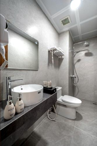 a bathroom with a sink and a toilet and a mirror at Hoa Lu Majestic Hotel - Phố cổ Hoa Lư, Ninh Bình in Kỳ Vĩ