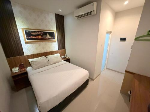 a bedroom with a white bed in a room at DOM Hotel Jogja in Yogyakarta