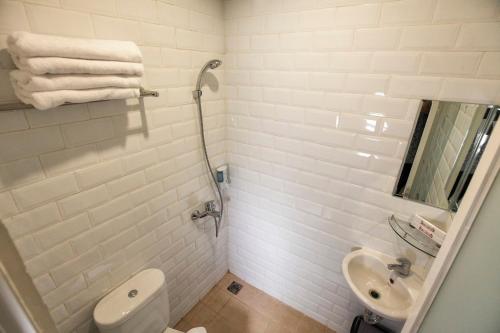 a white bathroom with a toilet and a sink at DOM Hotel Jogja in Yogyakarta
