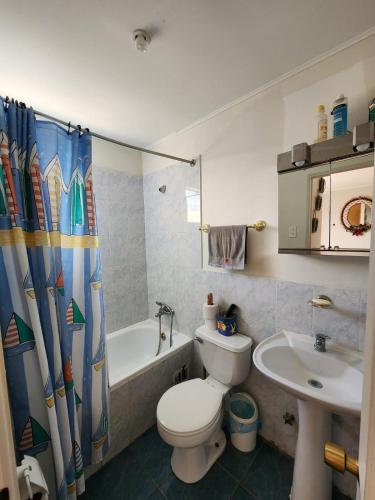 a bathroom with a toilet and a tub and a sink at Algarrobo, house in a condominium in Algarrobo