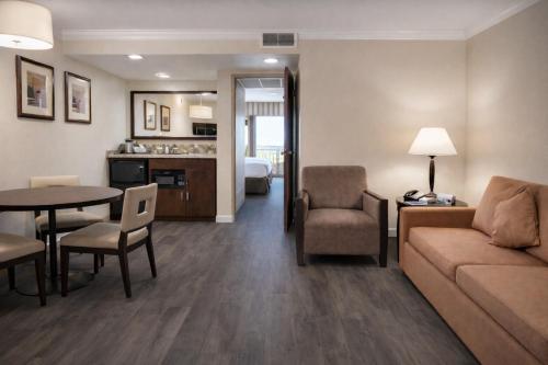 a living room with a couch and a table at The Buena Park Grand Hotel & Suites in Buena Park